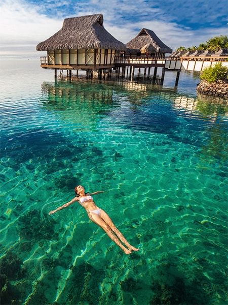 A woman floating in water in Tahiti