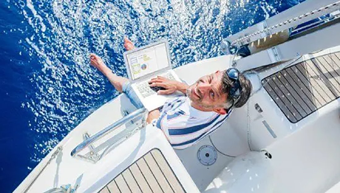 Charter broker working on a yacht with a laptop